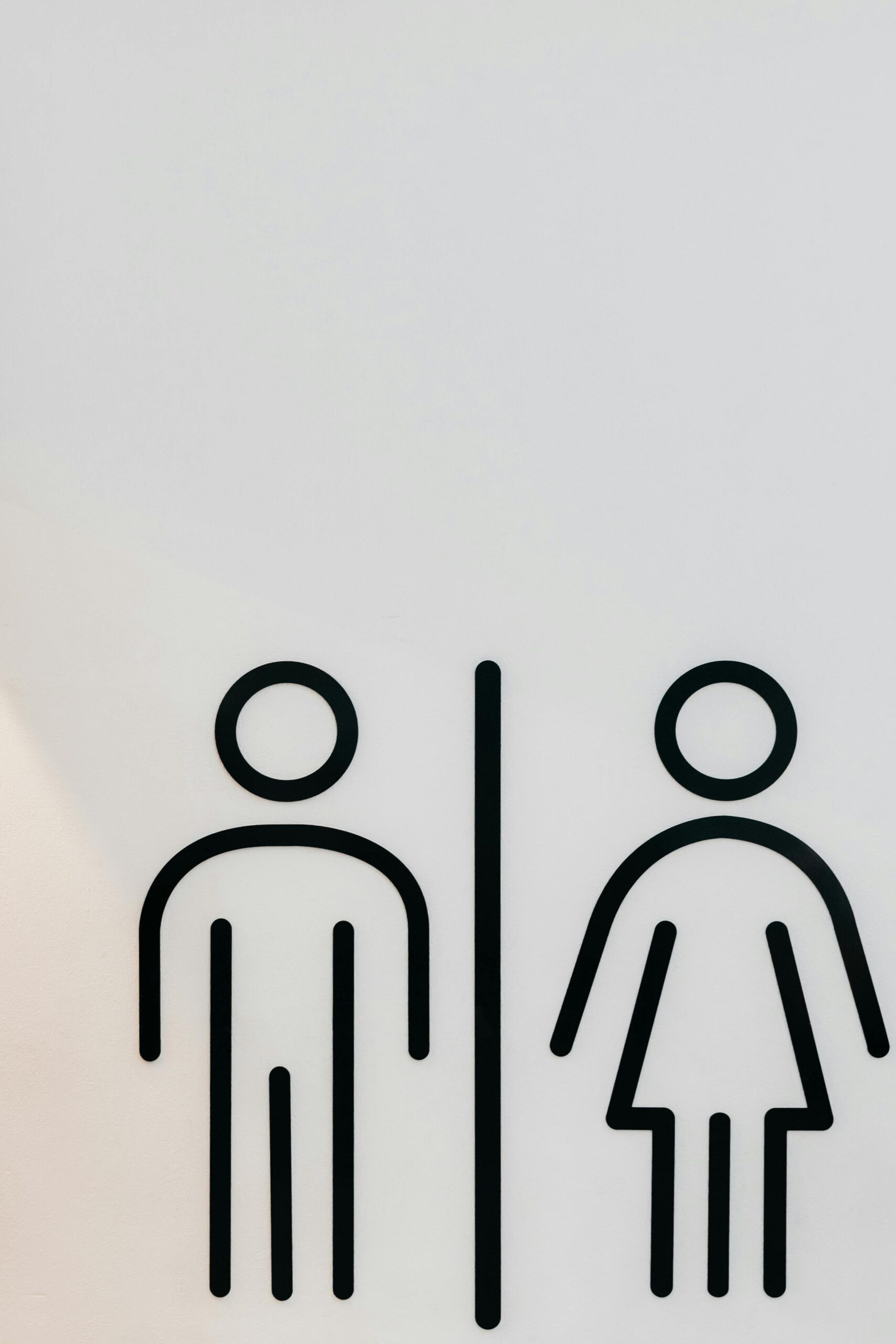 Simple black and white design of unisex restroom signage on a clean surface.